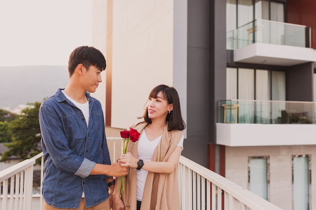 Photo gratuite couple marchant tenant à une rose