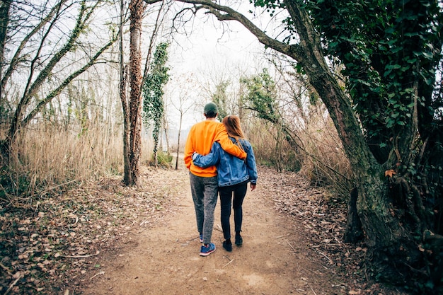 Couple marchent ensemble sur le sentier forestier de gravier