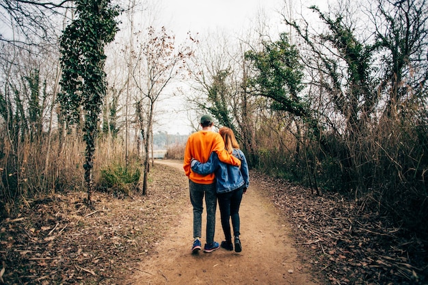 Couple marchent ensemble sur le sentier forestier de gravier