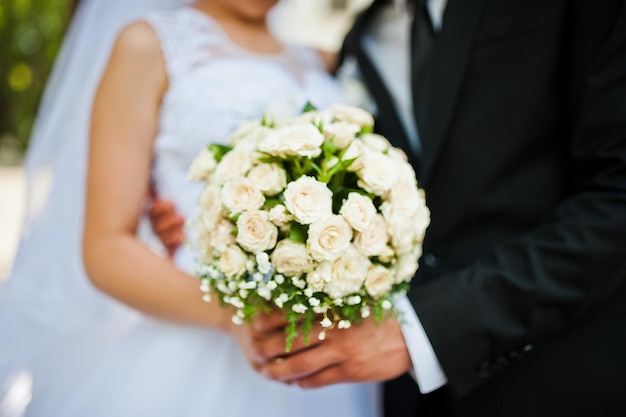 Couple de mariage avec bouquet à portée de main