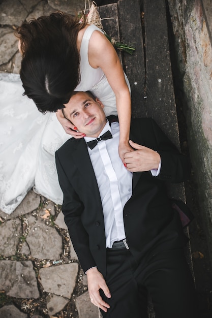 Photo gratuite couple de mariage posant sur le banc