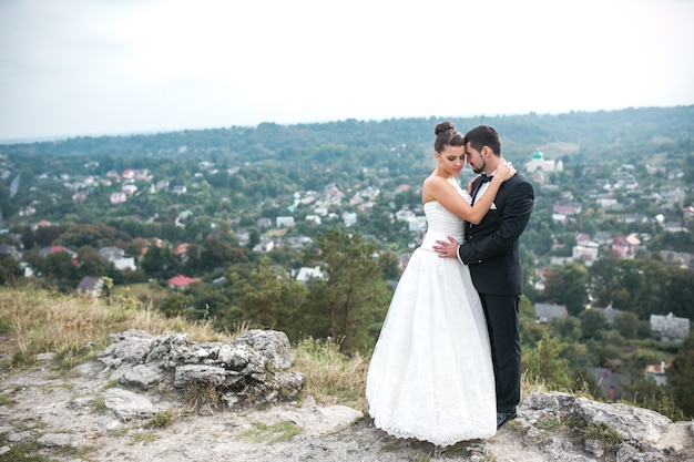 Couple de mariage posant pour la caméra sur la bosse