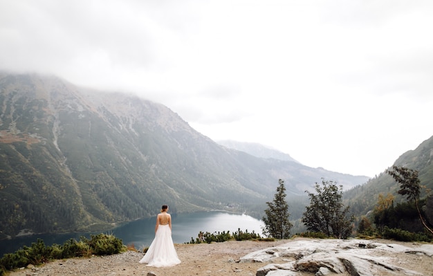 Couple de mariage romantique amoureux debout du lac Sea Eye en Pologne. Montagnes des Tatras.