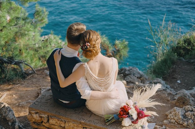 Le couple de mariage romantique se repose sur un fond d'une belle île en mer et apprécie une belle vue de Monténégro