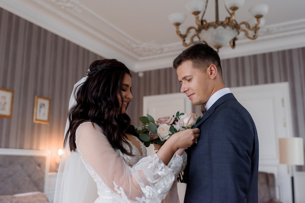 Couple de mariage se prépare ensemble pour la cérémonie de mariage avec une vinaigrette à la boutonnière