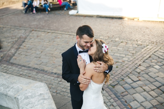 Couple marié embrassant sur la rue