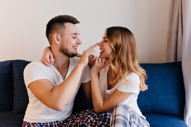 Couple marié excité s'amuser le matin du week-end. Plan intérieur d'un homme et d'une femme positifs exprimant leur amour.