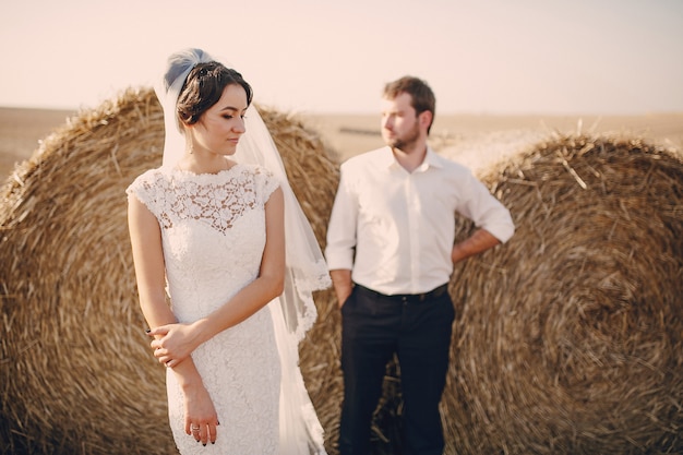 Photo gratuite couple marié avec des rouleaux de paille