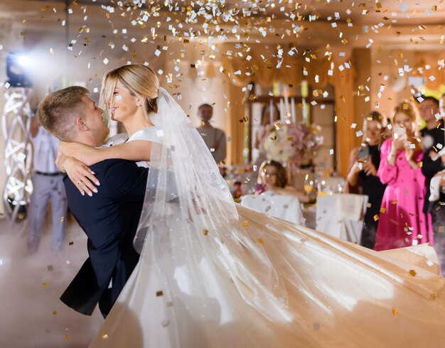 Couple mariée agitant tout en dacning avec des confettis