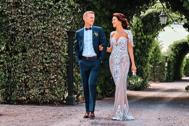 Un couple de mariés heureux se promène dans le magnifique jardin.