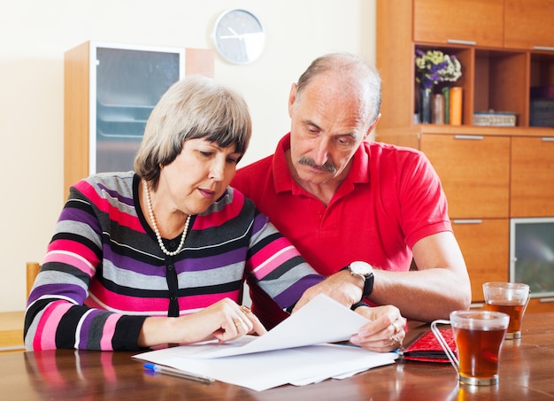 Photo gratuite couple mature, lecture de document financier