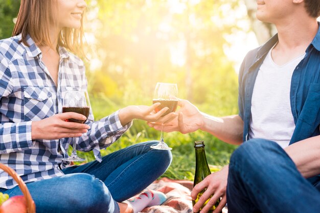 Couple méconnaissable ayant un moment romantique à l&#39;extérieur avec du vin