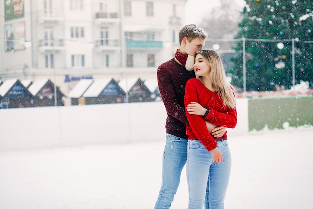 Couple mignon et affectueux dans un chandail rouge dans une ville d'hiver