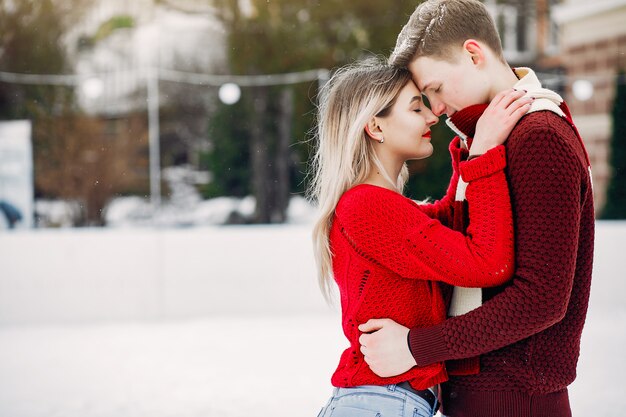 Couple mignon et affectueux dans un chandail rouge dans une ville d'hiver