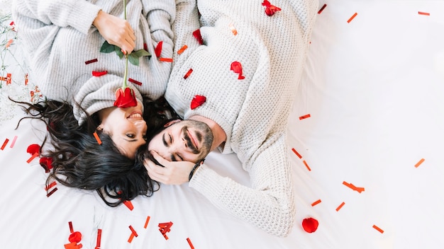 Couple mignon sur des confettis et des pétales de rose