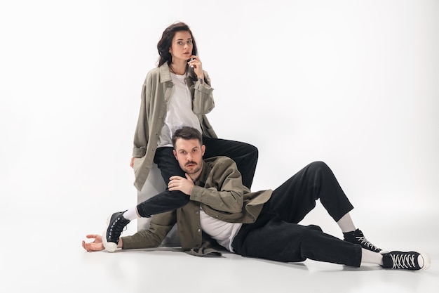 Couple à la mode branché isolé sur fond de studio blanc.