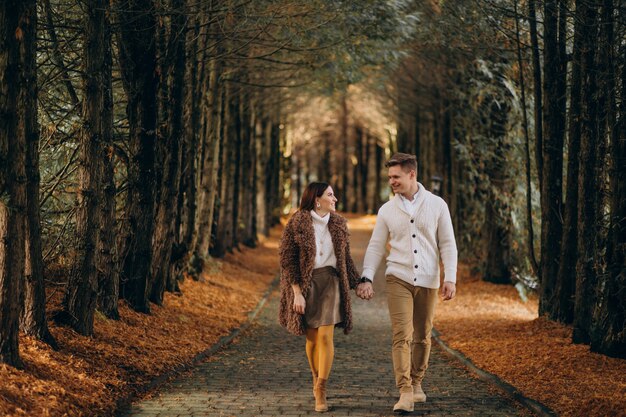 Couple de mode ensemble marchant dans le parc