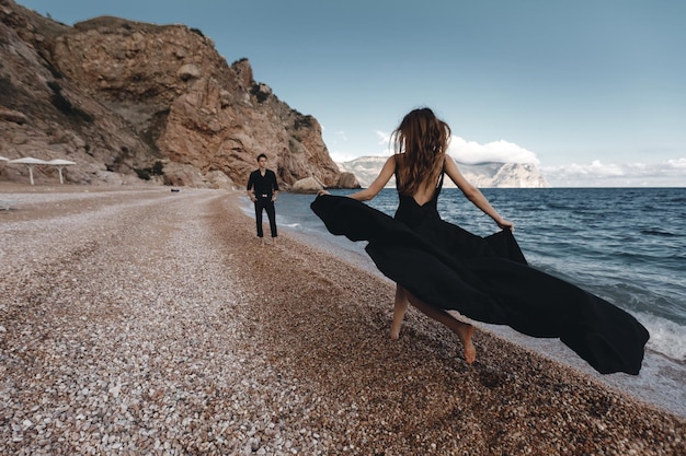 couple de mode en robe noire et costume en plein air