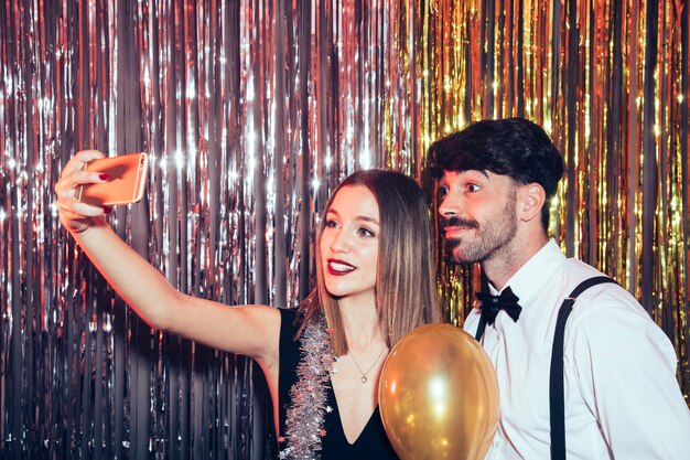 Couple moderne prenant selfie sur la fête du nouvel an