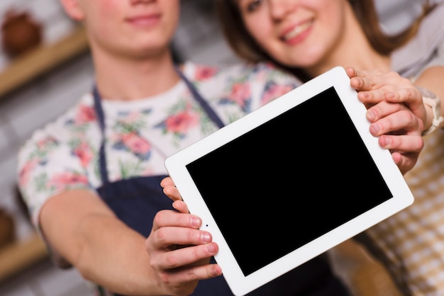 Couple montrant une tablette moderne ensemble