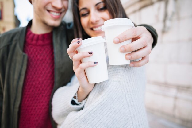 Couple montrant des tasses en plastique