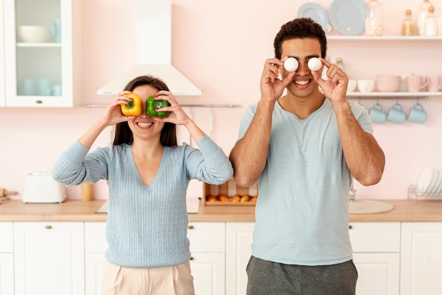 Couple moyen pose avec oeufs et poivrons