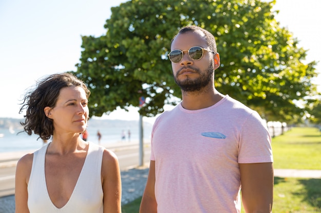 Couple multiethnique marchant dans le parc