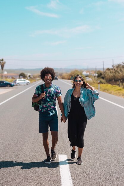 Couple multiethnique marchant sur la route