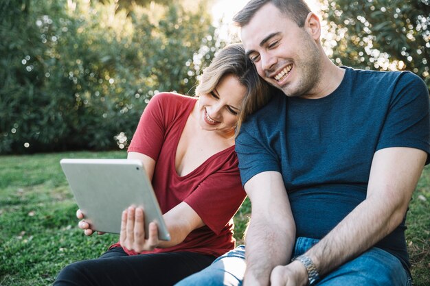 Couple, navigation tablette sur le parc