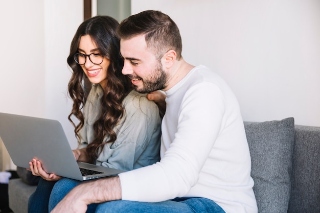 Couple avec ordinateur portable sur le canapé