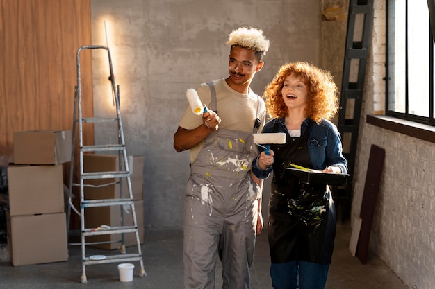 Couple peignant les murs de leur nouvelle maison ensemble