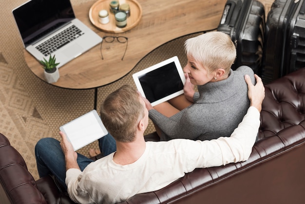 Couple de personnes âgées à angle élevé à la recherche sur leurs tablettes