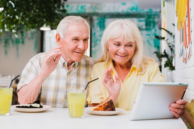 Couple de personnes âgées ayant un appel vidéo sur tablette