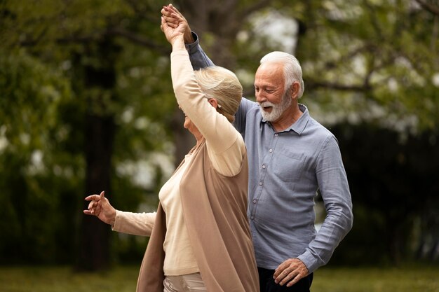 Couple de personnes âgées coup moyen dansant dans le parc