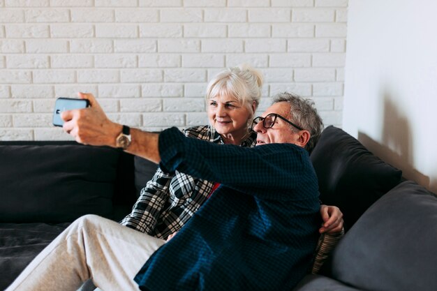 Photo gratuite couple de personnes âgées dans la maison de retraite prenant selfie