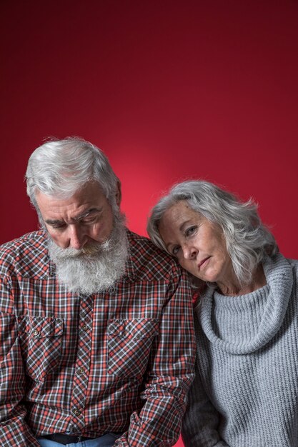 Couple de personnes âgées déprimé sur fond coloré