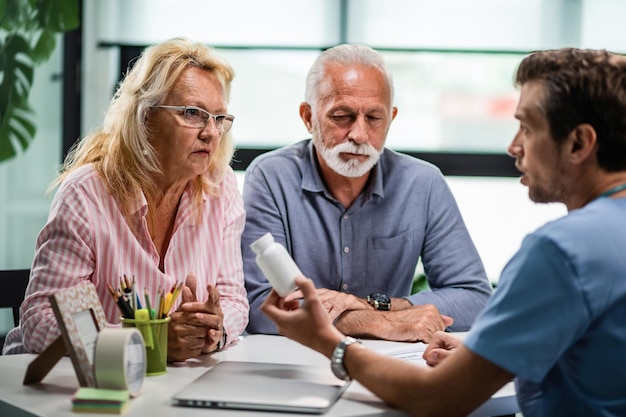 Couple de personnes âgées discutant avec un médecin de médicaments sur ordonnance lors de consultations