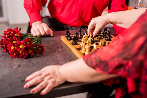 Couple de personnes âgées jouant aux échecs