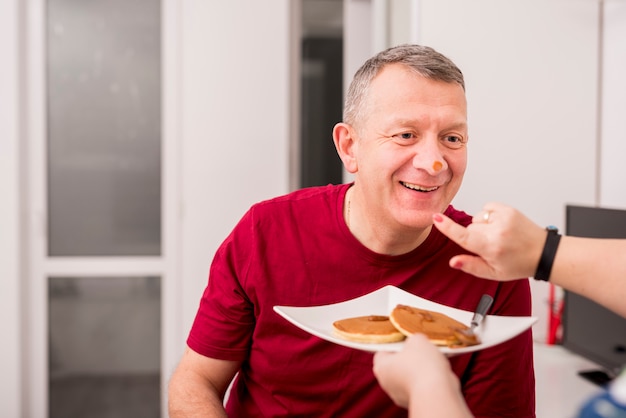 Photo gratuite couple de personnes âgées jouant avec des crêpes