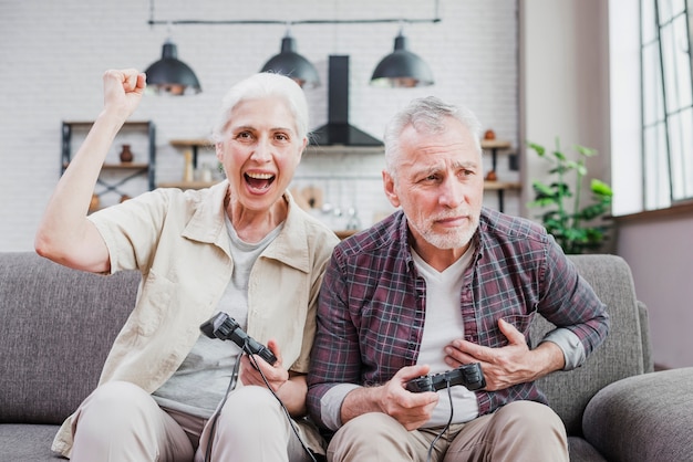 Couple de personnes âgées jouant à des jeux vidéo