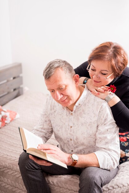 Couple de personnes âgées lisant