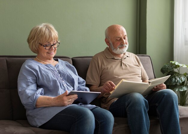 Couple de personnes âgées avec livre et tablette