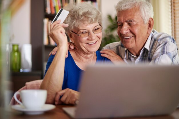 Couple de personnes âgées naviguant sur Internet sans aucun problème