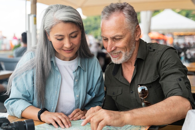 Couple de personnes âgées à plan moyen avec carte