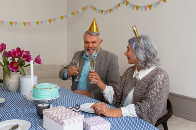 Couple de personnes âgées à plan moyen célébrant l'anniversaire