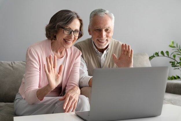 Couple de personnes âgées à plan moyen avec ordinateur portable