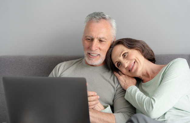 Couple de personnes âgées à plan moyen avec ordinateur portable