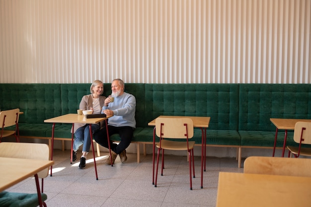 Couple de personnes âgées plein coup assis au restaurant