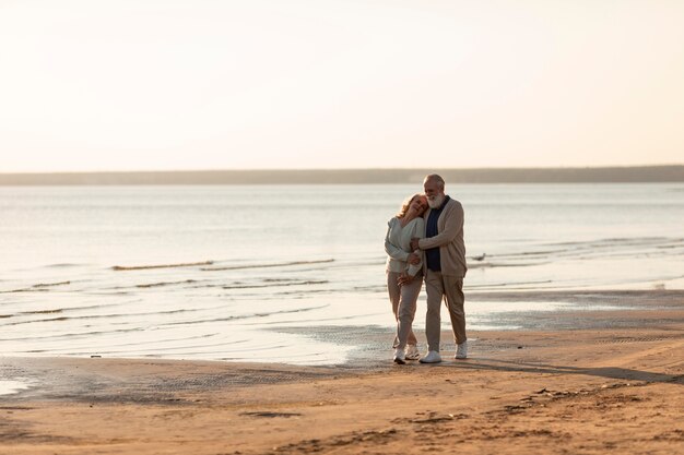 Couple de personnes âgées à plein coup à la plage