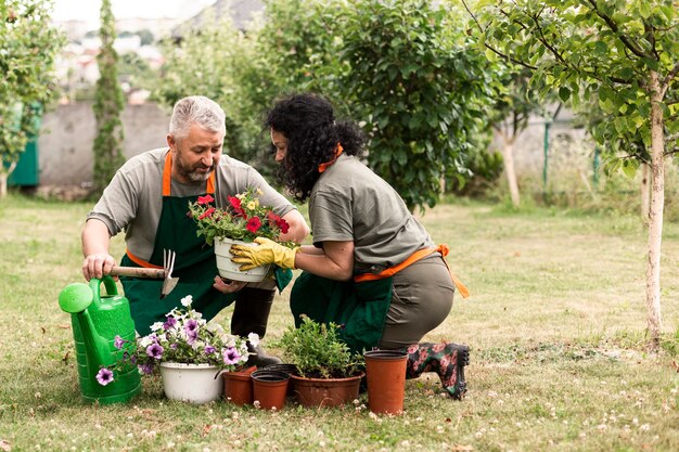 Couple de personnes âgées s'occupant des fleurs